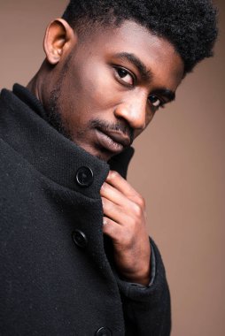 Close-up of African elegant man in black jacket looking at camera