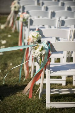 Outdoor Wedding Aisle with Floral and Ribbon Chair Decor