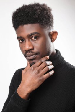 Portrait of pensive man looking at the camera, touching his chin