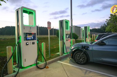 A car getting power at an EV charging location in a parking lot.