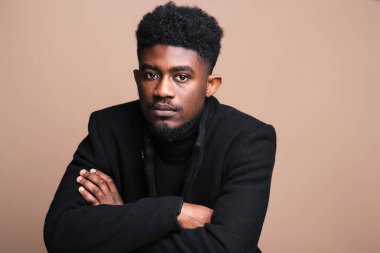Close-up of African elegant man in black jacket looking at camera