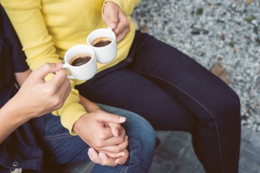 El ele tutuşan ve bahçede kahve içen çiftler