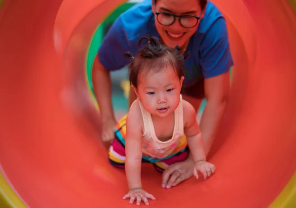 Asian baby girl playing with mom on playground — Stock Photo, Image