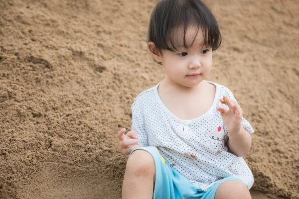 Little girl playing on the sand pile — Stock Photo, Image