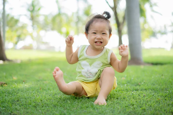 Asian baby girl sitting on the lawn. — Stock Photo, Image