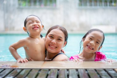 Asyalı genç anne ve iki sevimli kıvırcık küçük kız bebek havin