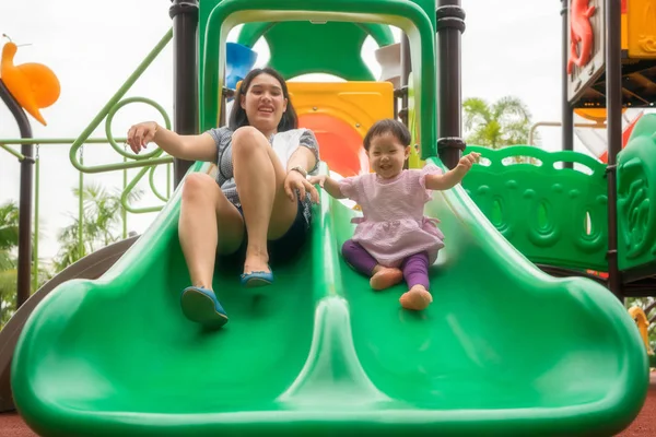 Asian mother and daughter are happiness and enjoy playing slide — Stock Photo, Image