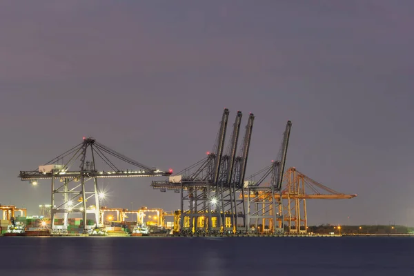 Cargo cranes in industrial port at twilight. — Stock Photo, Image