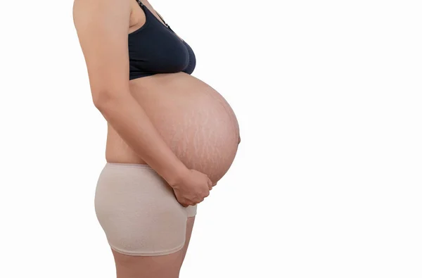 Bauch einer schwangeren Frau mit Dehnungsstreifen auf weißem Hintergrund Stockfoto