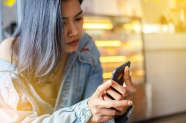 Kafede akıllı telefon kullanan bir kız.