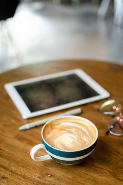 ahşap masa üzerinde modern çalışma araçları ile kahve kupa