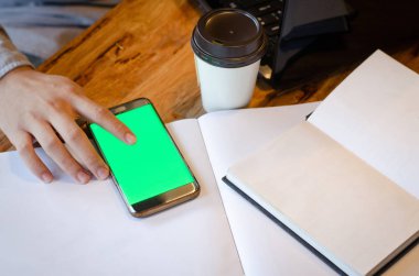 Kafede akıllı telefon kullanan bir adam.