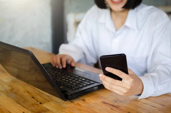 Jeune femme utilisant un téléphone intelligent dans le café — Photo