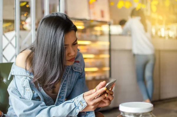 Chica usando el teléfono inteligente en la cafetería — Foto de Stock