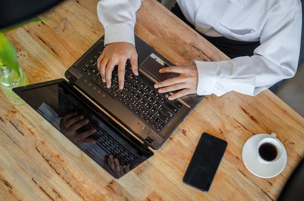 Jeune femme utilisant un ordinateur portable sur une table en bois — Photo