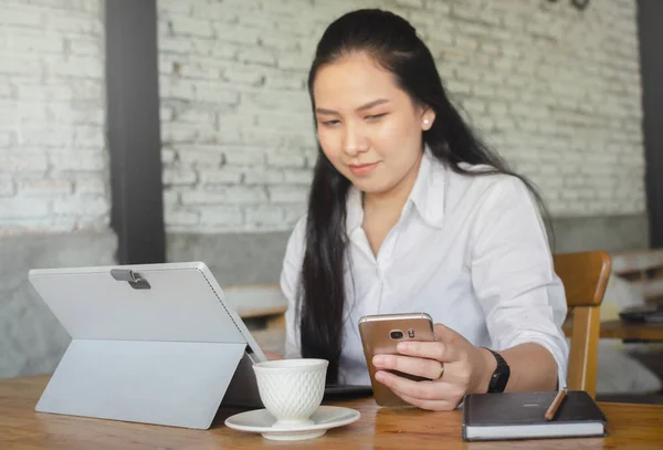 Kafede dizüstü bilgisayar kullanan genç bir kadın — Stok fotoğraf