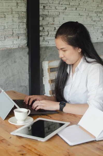 Jeune femme utilisant un ordinateur portable dans un café — Photo