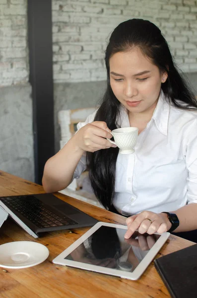 Jeune femme boire du café tout en travaillant dans le café — Photo