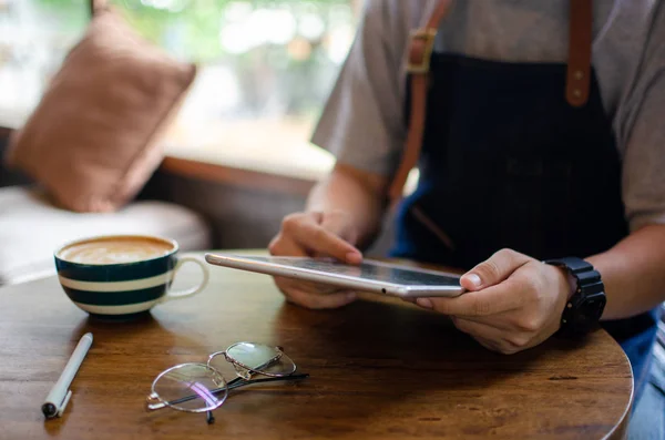 Homme utilisant tablette sur table en bois — Photo