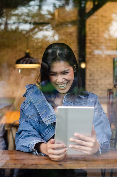 Mujer asiática feliz usando tableta en la cafetería — Foto de Stock