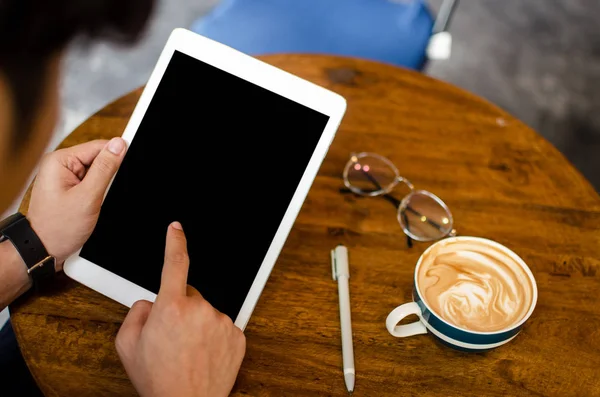 Man using tablet on wooden table Royalty Free Stock Images