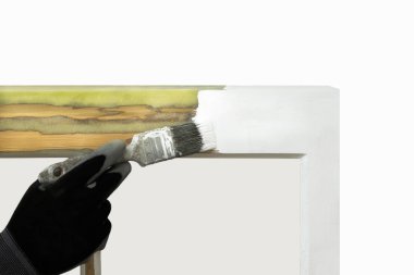 Restore edilmiş sash pencerelerini boyatan bir kişinin yakın çekimi.