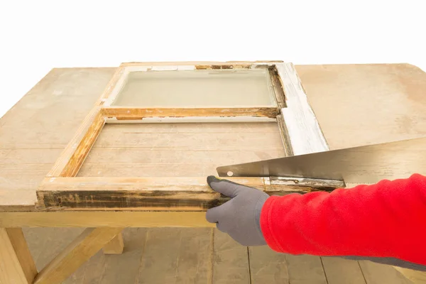 Tischler mit der Handsäge bei der Renovierung eines alten Fensterflügels — Stockfoto