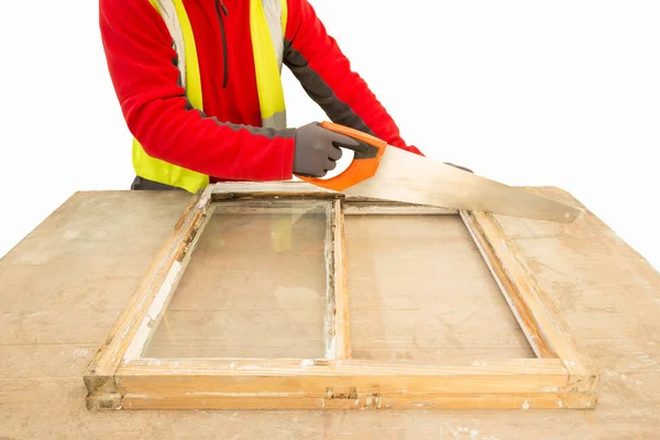 Carpinteiro usando uma serra manual durante a reparação de uma antiga moldura da janela sa — Fotografia de Stock