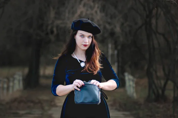 Woman dressed in retro style searching for something in her purse