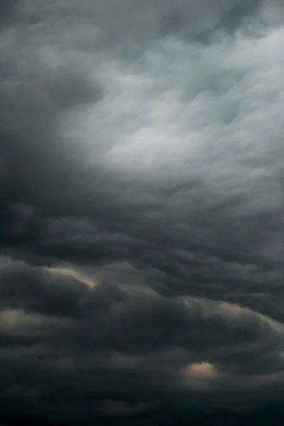 Dramatic black sky cloud storm pattern sun peaking through background