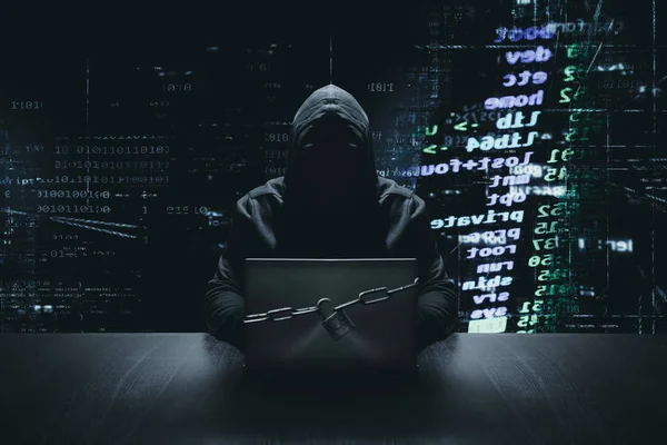 バイナリ コードの背景の前でロックされたコンピューターで匿名のハッカー ロイヤリティフリーのストック画像