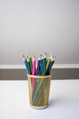 Bir kalem durumda beyaz arka plan üzerinde renkli kalemler