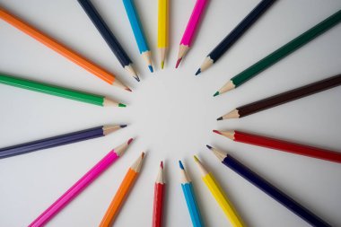 Beyaz arkaplanda renk tekerleği renklerine göre düzenlenmiş renkli kalemler