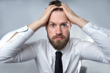 Korkmuş ve mutsuz adam portresi. İş adamı izole üzerinde gri arka plan ayakta