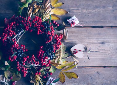 Çelenkli sonbahar kompozisyonu, kuru yapraklar hediyeler ve böğürtlenler / sonbahar çelengi