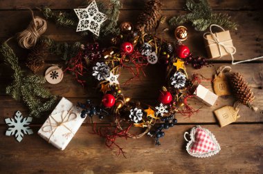 Çam kozalaklı Noel çelengi, meşe palamudu ve sonbahar meyveleri, hediyeler / Noel çelengi yapma süreci / kış tatili için el yapımı süslemeler