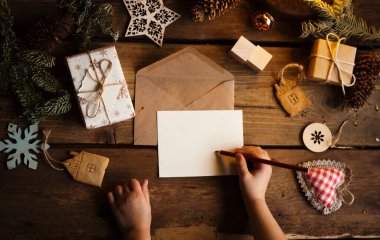 Çam kozalaklı Noel çelengi, meşe palamudu ve sonbahar meyveleri, hediyeler / bir çocuk Noel Baba 'ya bir mektup yazar