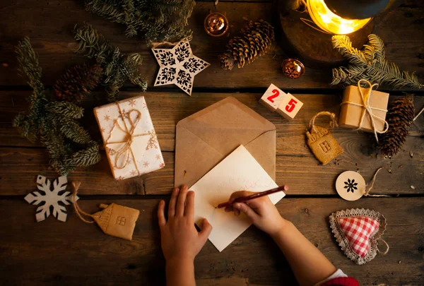 Çam kozalaklı Noel çelengi, meşe palamudu ve sonbahar meyveleri, hediyeler / bir çocuk Noel Baba 'ya bir mektup yazar