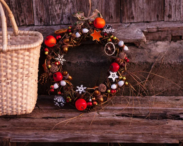 Tahta duvarda asılı Noel çelengi