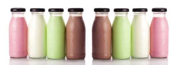 Süt beyaz arka plan üzerinde izole şişelerde