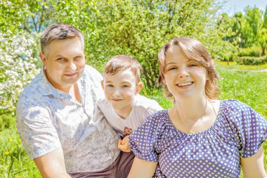 Mutlu bir aile açık havada bir güneşli yaz gününde vakit. mutlu anne ve baba oğul Park yaz güneşli günde kucaklama.