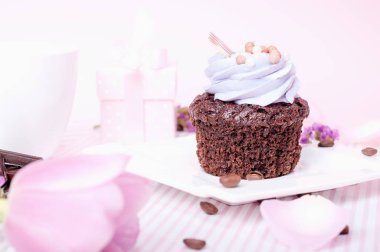 Pembe bir arka plan üzerinde beyaz bir daire üzerine krema ile çikolatalı kek