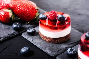 Jöle, böğürtlen, ahududu ve çilek siyah bir arka plan ile pasta