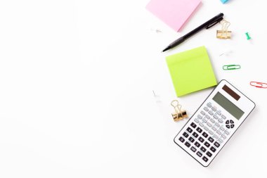 Hesap makinesi, kalem, not kağıdı beyaz bir arka plan üzerinde