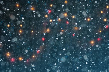 Noel mavi bokeh zekâ beyaz kar taneleri ve kırmızı ve sarı ışıklar
