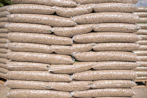 Pilha de sacos de plástico cheio com pellets de madeira — Fotografia de Stock