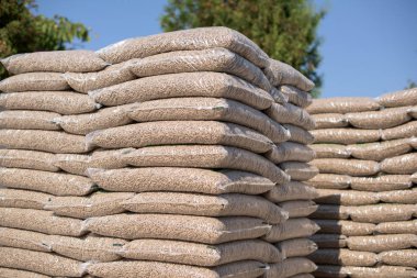 Piles of plastik bags full with wooden pellets 