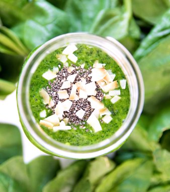 Chia ve Hindistan cevizi ile kavanoza yeşil güler yüzlü, ek yükü camına çipler, sebze ile sağlıklı içecek ıspanak yaprakları