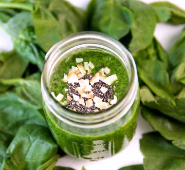 Chia ve Hindistan cevizi ile kavanoza yeşil güler yüzlü, ek yükü camına çipler, sebze ile sağlıklı içecek ıspanak yaprakları