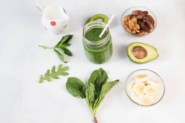 Cam üst görünümden Beyaz ahşap zemin üzerine yeşil sebze güler yüzlü